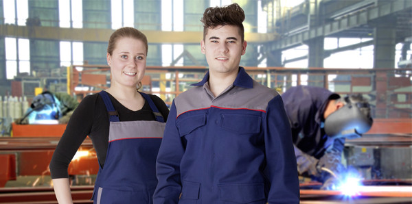 Junge brünette Frau und junger brünetter Mann stehen in Schweilerschutz Schutzkleidung in der Werkstatt.