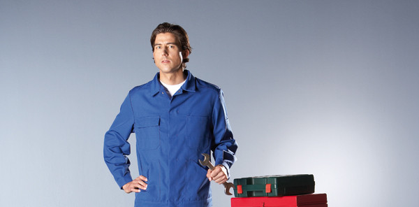 Mann steht neben Werkzeugkasten in robuster Berufskleidung